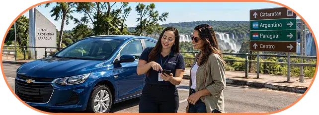Equipe da IguFoz orientando clientes ao lado de um carro azul, com placas de sinalização ao fundo